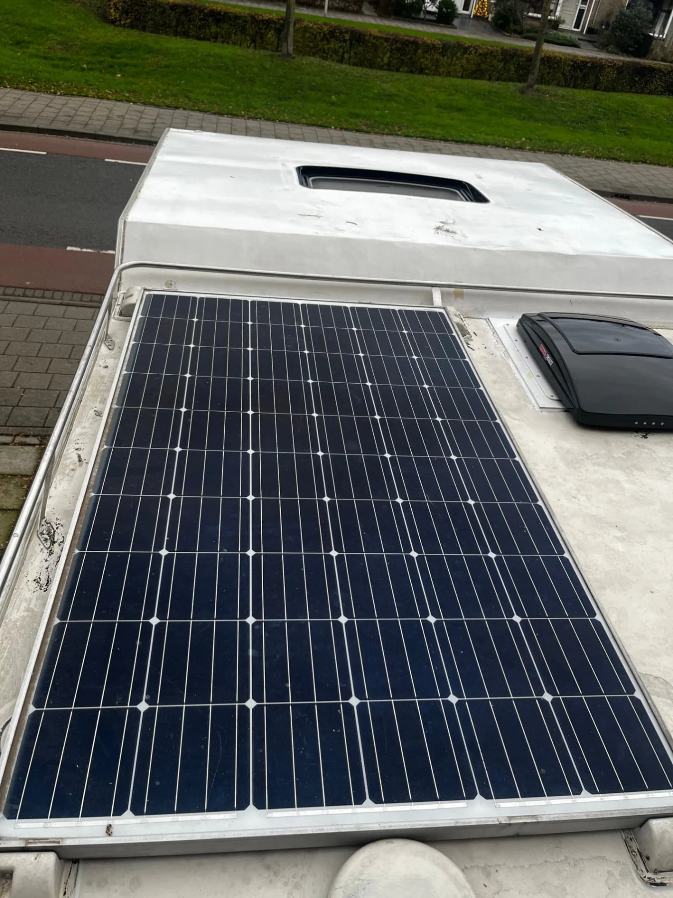 Zonnepaneel en dakluiken op het dak van een camper